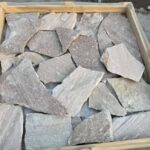 Collection of irregular flagstone pavers in various colors and textures